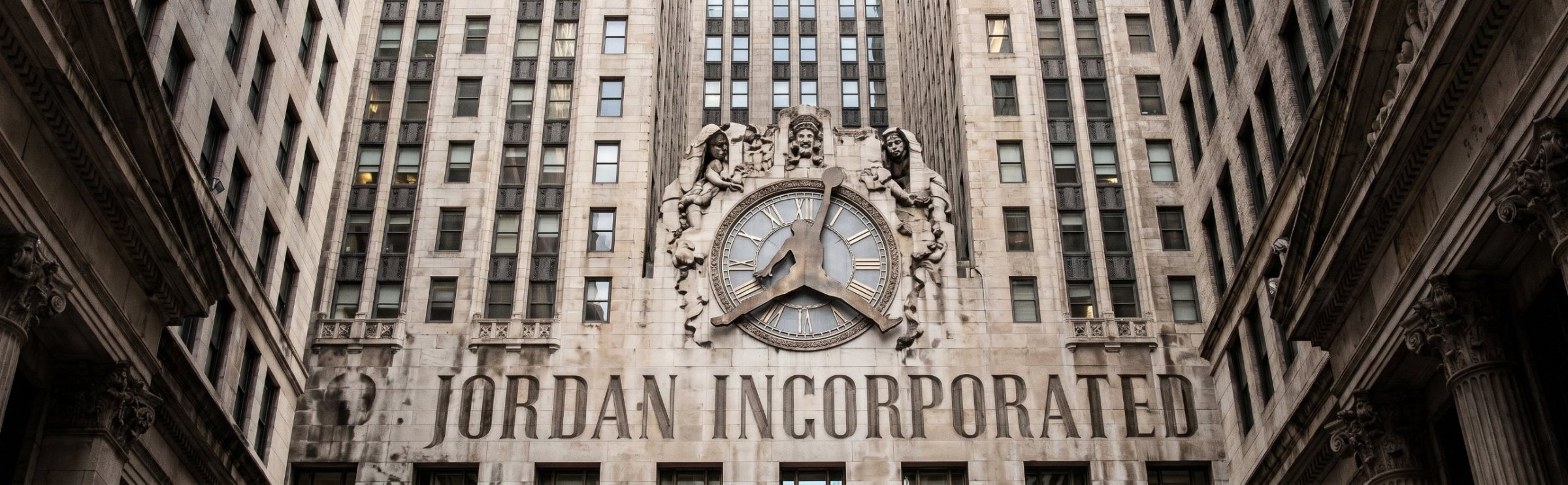 Frame from the CEO Jordan TV spot: a skyscraper facade carved with JORDAN INCORPORATED.